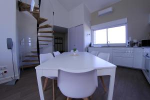 - une cuisine blanche avec une table et des chaises blanches dans l'établissement House 35 minutes from Futuroscope, à Saint-Jean-de-Sauves