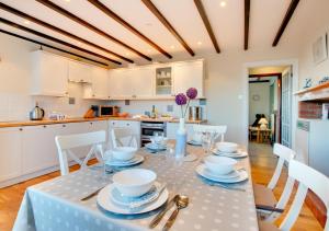 a kitchen with a table with dishes on it at Castle Point Cottage Craster in Craster