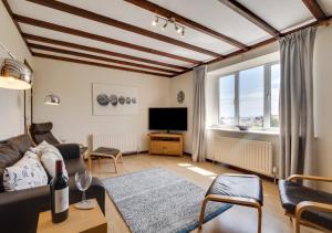 a living room with a couch and a tv at Castle Point Cottage Craster in Craster