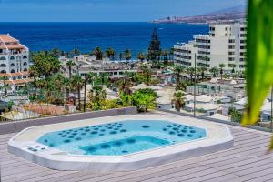 a swimming pool on a deck with a view of the ocean at Spring Hotel Bitácora in Playa de las Americas