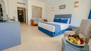 a hotel room with a bed and a bowl of fruit on a table at Club Reef Resort & Spa in Sharm El Sheikh