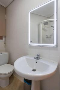 a bathroom with a white sink and a toilet at Apartamento en la Ribera Bilbao Anfitrión Verónica in Bilbao
