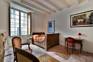 - une chambre avec un lit, un bureau et une chaise dans l'établissement Logis Cointereau, à Baugé