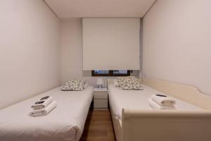 two beds sitting next to each other in a room at Apartamento en la Ribera Bilbao Anfitrión Verónica in Bilbao