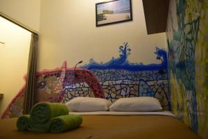 a bedroom with a bed with a painting on the wall at Pondok IJo Villa in Timuran