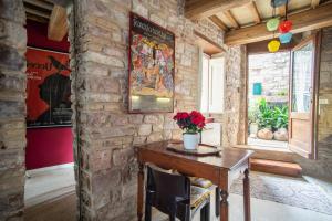 Zimmer mit einem Holztisch in einer Steinmauer in der Unterkunft La Viola di Assisi in Assisi