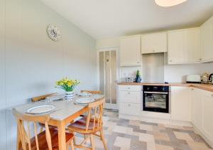a kitchen with a table and chairs and an oven at Bolams Lodge in Ancroft