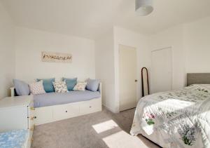 AncroftにあるBolams Lodgeの白いベッドルーム(ベッド1台、ベッド1台、ベッドスカート付)