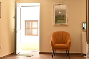 uma cadeira laranja num quarto com um espelho em CASA DA `VÓ MICAS em Cardeal