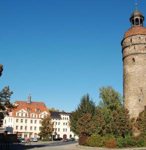 a tall brick tower in front of a building at Jaekels Ferienwohnung in Görlitz