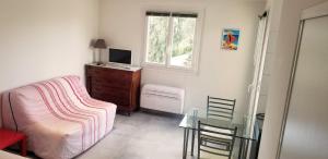 een slaapkamer met een tafel, een bed en een raam bij Studio dans résidence avec piscine in Calvi