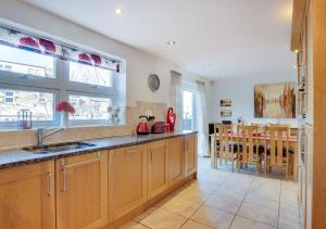 a kitchen with wooden cabinets and a dining room at Twin Palms No 2 in North Sunderland