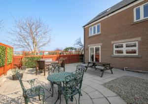 a patio with a table and chairs and a building at Twin Palms No 2 in North Sunderland