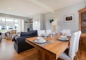 uma sala de jantar e sala de estar com uma mesa de madeira em Porthole Cottage em Beadnell
