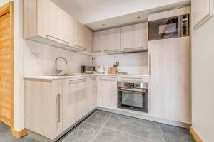 una cucina con armadi bianchi e lavandino di Cosy apartment 2 - 6 persons a Tignes