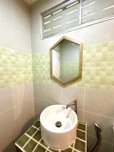 a bathroom with a sink and a mirror at เซน บัลโคนี่ เฮ้าส์ ระนอง in Ban Lum Than