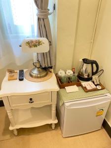 a table with a lamp on top of a dresser at เซน บัลโคนี่ เฮ้าส์ ระนอง in Ban Lum Than