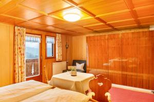 1 Schlafzimmer mit 2 Betten, einem Tisch und einem Fenster in der Unterkunft Ferienhaus Dünser in Bizau