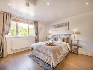a bedroom with a large bed and a window at Clay Lake Cottages - Dads Shed in Covenham