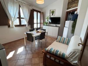 Il comprend une cuisine et un salon avec une table et un canapé. dans l'établissement Casa Luisa IUN Q3032 Appartamento a 5 minuti in macchina dal Mare, à Bari Sardo