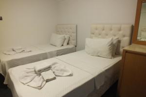 een hotelkamer met 2 bedden en handdoeken erop bij Avalon otel in Kuşadası
