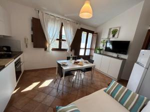 une cuisine avec une table et des chaises dans l'établissement Casa Luisa IUN Q3032 Appartamento a 5 minuti in macchina dal Mare, à Bari Sardo