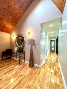 un soggiorno con pavimento in legno e specchio di Fairways Villa Newcastle a Newcastle