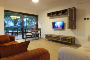 een woonkamer met een flatscreen-tv aan de muur bij Avalon otel in Kuşadası