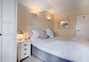 ポースレーヴェンにあるMariners IIのベッドルーム(大きな白いベッド1台、ナイトスタンド付)