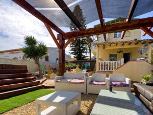 a patio with couches and tables and a house at Calpe chalet privado piscina a 5min de la playa y centro jacuzzi barbacoa wifi aire in Calpe
