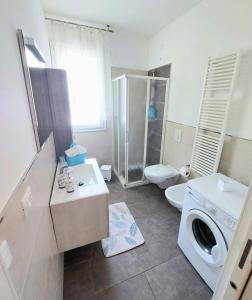 une salle de bain avec un lavabo et une machine à laver dans l'établissement Appartamento Palazzo Moretto, à Chioggia