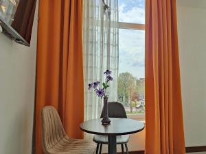 wazon z kwiatami na stole przed oknem w obiekcie CN-Hotel w Arnhem