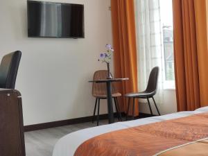 een hotelkamer met een tafel en twee stoelen en een televisie bij CN-Hotel in Arnhem