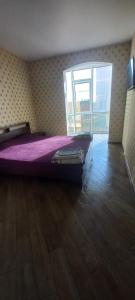 1 dormitorio con cama y ventana grande en 26 Perlyna Arcadia apartment, en Odessa