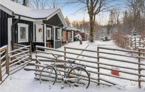 un vélo garé à côté d'une clôture dans la neige dans l'établissement 1 Bedroom Cozy Home In rkelljunga, à Orkelljunga