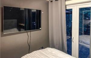 - une chambre avec un lit et une télévision murale dans l'établissement 1 Bedroom Cozy Home In rkelljunga, à Orkelljunga