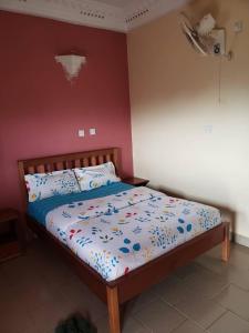 a bedroom with a bed with a bedspread with flowers on it at Appart'hotel britannia in Yaoundé