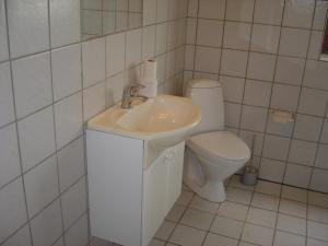 Baño blanco con aseo y lavamanos en Landstedet, en Gram