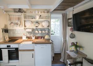 a kitchen with white cabinets and a counter top at Molly Muppet in Mousehole