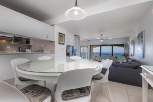 a dining room and living room with a table and chairs at 802 The Bermudas - by Stay in Umhlanga in Durban