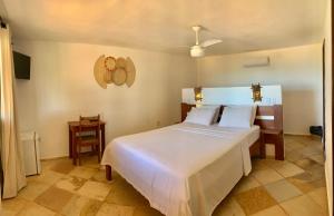 a bedroom with a large white bed in a room at Pousada Borboleta in Canoa Quebrada