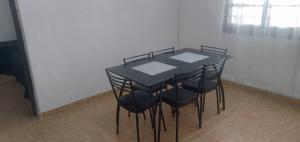 a black table with black chairs in a room at Casa cercana al Estadio Madre de Ciudades in Santiago del Estero