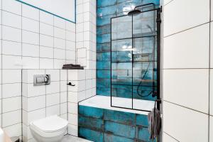 La salle de bains est pourvue de toilettes et d'une douche en verre. dans l'établissement Apartament Plac Jana Pawła 7 Centrum Wrocław, à Wrocław