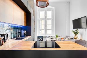 - une cuisine avec un comptoir en bois dans l'établissement Apartament Plac Jana Pawła 7 Centrum Wrocław, à Wrocław