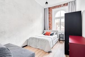 a white bedroom with a bed and a window at Apartament Plac Jana Pawła 7 Centrum Wrocław in Wrocław
