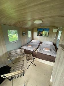 um quarto numa pequena casa com uma cama e uma mesa em Residence Safari Resort - Magic Bus em Borovany