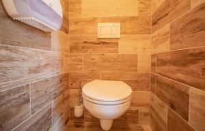 a bathroom with a toilet in a room with wooden walls at Residence Safari Resort - Magic Bus in Borovany