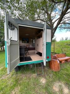 a tiny house with a door open in a yard at Residence Safari Resort - Magic Bus in Borovany