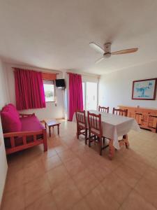 a living room with a table and a couch at Apartamentos Mar Bella in Es Cana