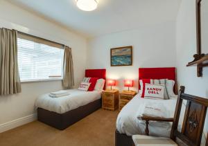 a bedroom with two beds and a window at Sandy Dell in Beadnell